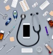 Flat lay of smart phone surrounded with various medical equipmen